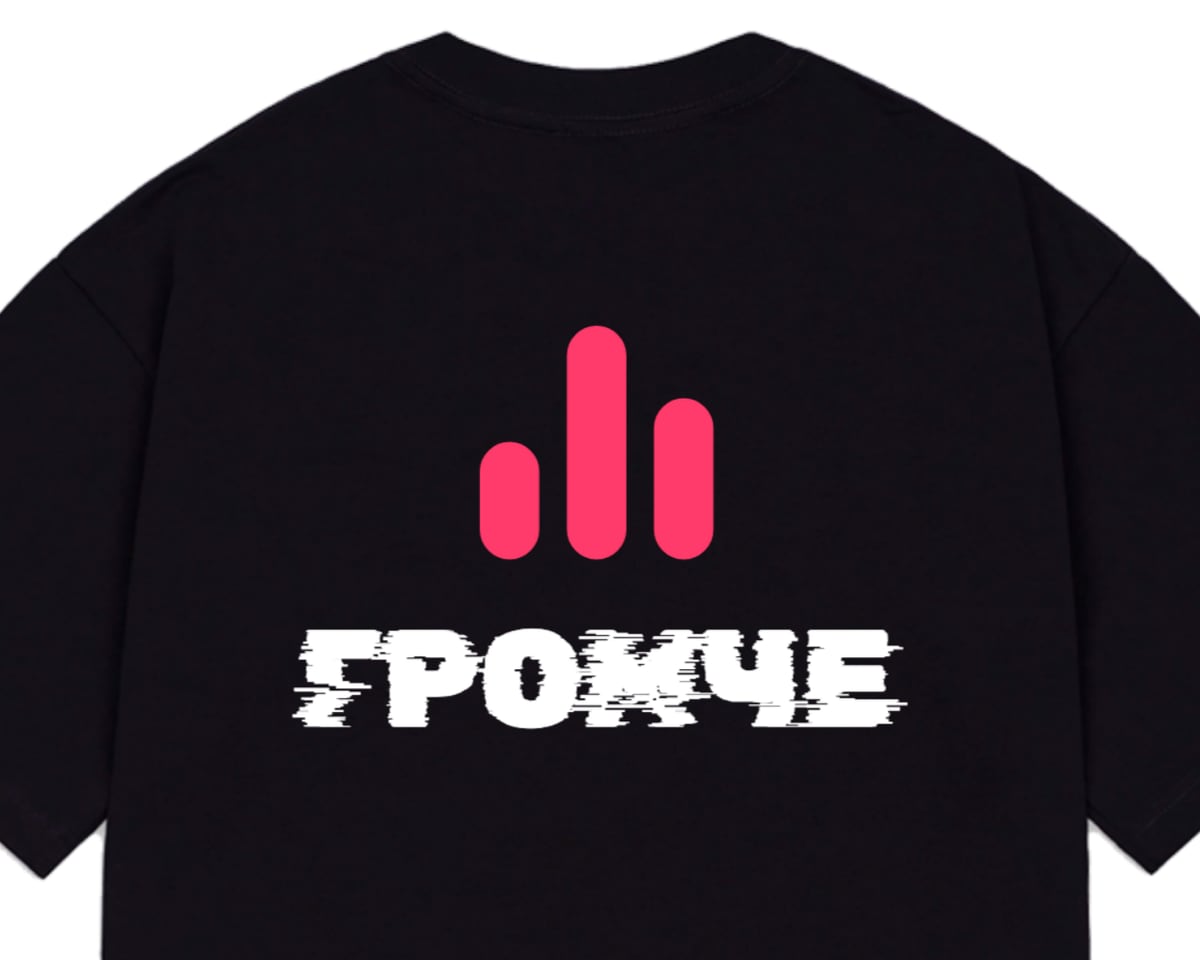 Чёрная оверсайз-футболка, на спине розовый эквалайзер и надпись «Громче»