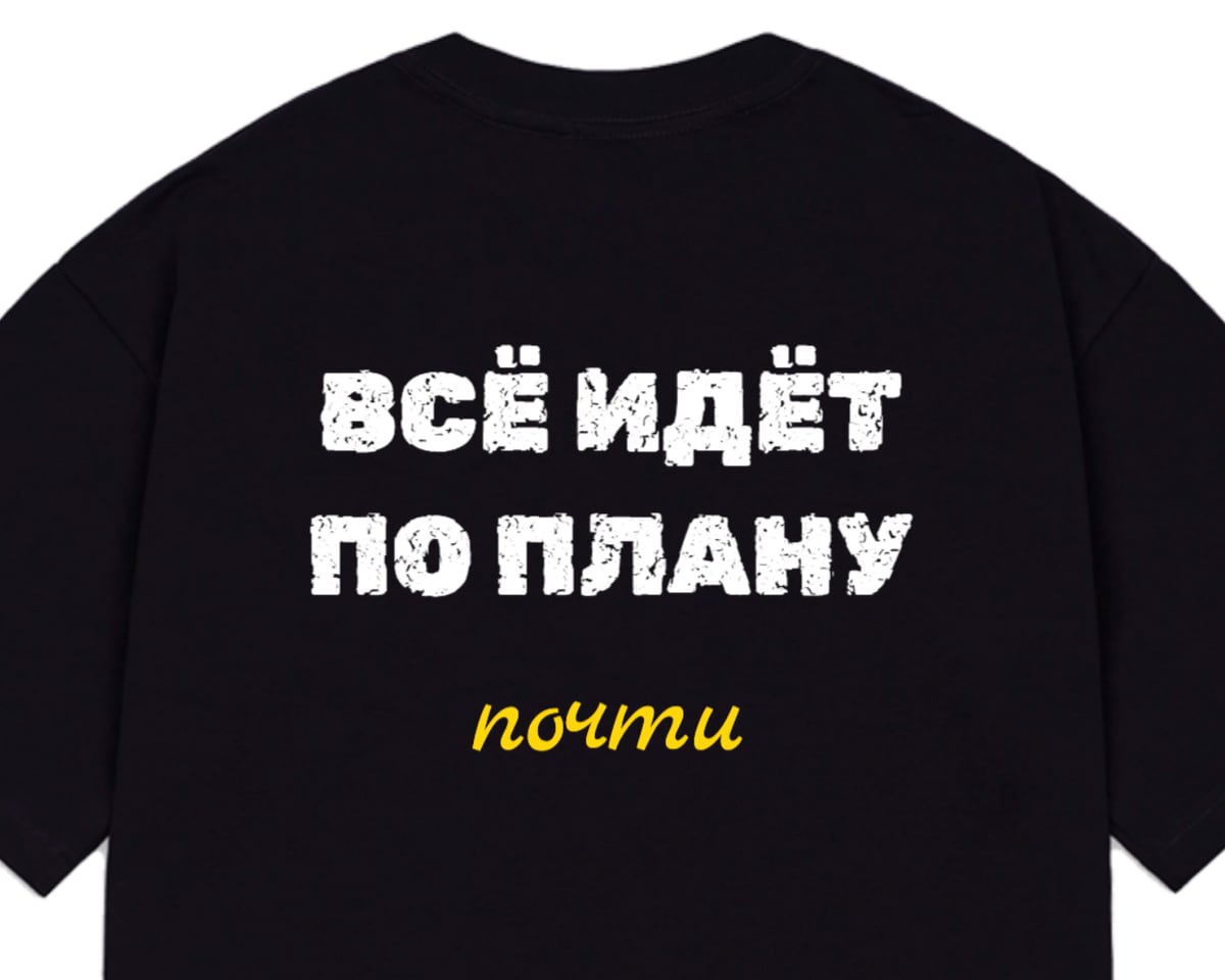 Чёрная оверсайз-футболка, на спине надпись «Всё идёт по плану» и маленькое жёлтое «почти»